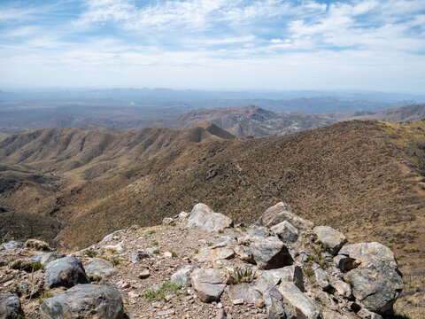 Mountaintop Rocky Overlook With A Great View Of Distant Desert Mountains