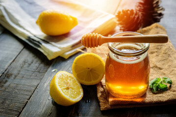 Honey with fresh lemon on wooden table background,  honey dipper