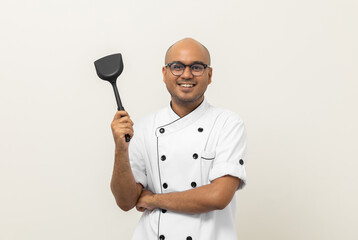 Naklejka premium Young handsome asian man chef in uniform standing with turner kitchen utensils various gesture action on isolated background. Cooking man Occupation chef People in kitchen restaurant and hotel.
