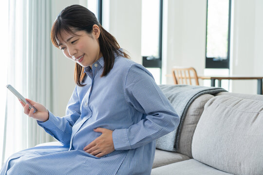 自宅で電話をかける日本人妊婦