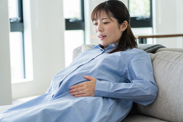 自宅で陣痛を感じる日本人妊婦 - obrazy, fototapety, plakaty