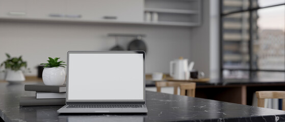 Notebook laptop mockup on modern black marble kitchen countertop in modern apartment kitchen