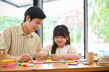 Cheerful young asian girl enjoy sculpting play dough, moulding clay with her art teacher