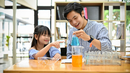 Fototapeta na wymiar Lovely cute young Asian girl having a fun learning experience with her sciences teacher
