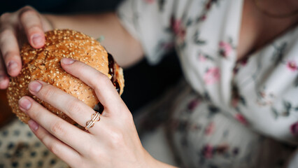 Pregnancy woman burger eating. Hungry pregnant girl biting hamburger. Fast food, people and...