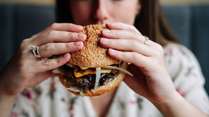 Fast food burger eat. Pretty Young Happy Woman Eating Tasty Hamburger. Junk Food Concept.