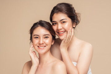 Two Asian woman with beauty face touching healthy skin care. Beautiful female models happy smiling...