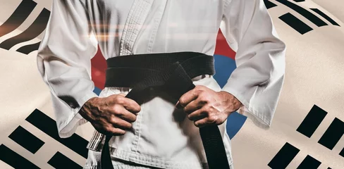 Photo sur Plexiglas Arts martiaux Midsection of martial artist holding belt against South Korean Flag
