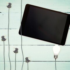 Bulbs and tablet on wooden background