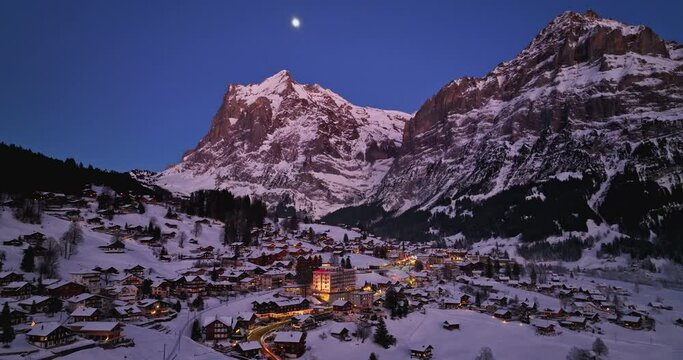 Panorama aerial Drone shot of Cottages chalets in Murren village at snowy winter night. M&uuml;rren traditional Walser mountain village in the Bernese Highlands of Switzerland. popular tourist spots.