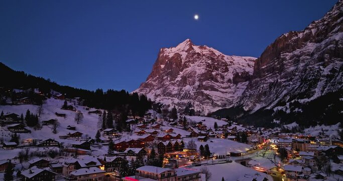 Panorama aerial Drone shot of Cottages chalets in Murren village at snowy winter night. M&uuml;rren traditional Walser mountain village in the Bernese Highlands of Switzerland. popular tourist spots.