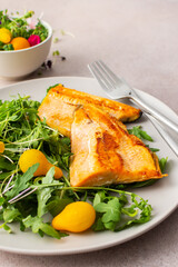 Delicious lunch with salad and fried char, healthy red fish and microgreens with cherry tomatoes, top view, copy space