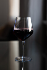 Glass of red wine on reflective glass table