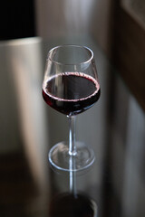 Glass of red wine on reflective glass table