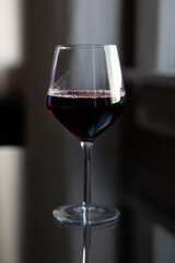 Glass of red wine on reflective glass table