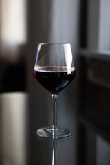 Glass of red wine on reflective glass table