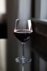 Glass of red wine on reflective glass table