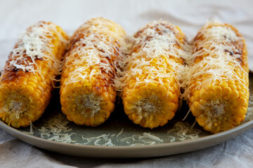 Homemade Garlic Parmesan Grilled Corn on a Plate, low angle view. Close-up.