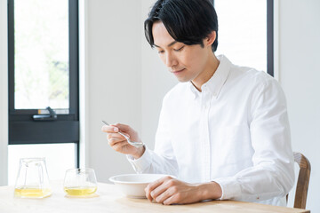 Fototapeta na wymiar 自宅でシリアルを食べる健康的な日本人男性