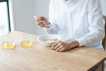 自宅でシリアルを食べる健康的な日本人男性