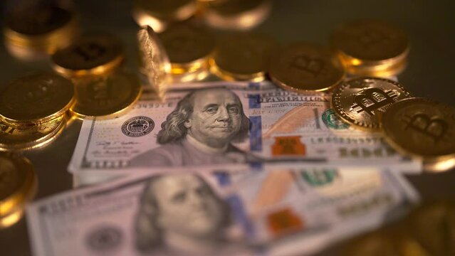 Spinning golden Bitcoin BTC over a dollar USD, filmed macro in low angle with slow movement to the side. Financial profit entering a crypto market. Cryptocurrency. Financial investment.