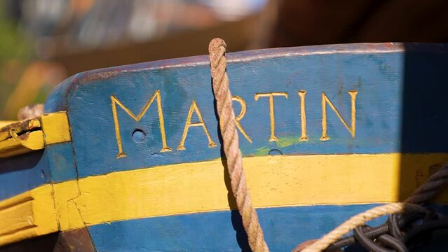 Close up shot of the name Martin carved into a wooden boat
