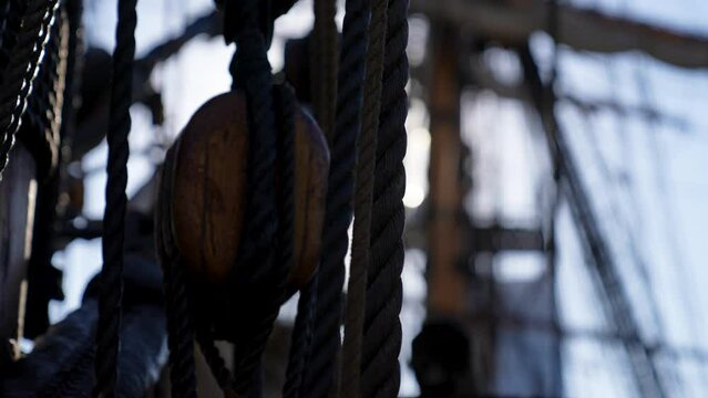 old naval warship rigging shallow depth of field with sun glare at sea concept