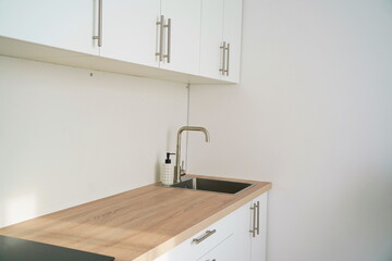 Kitchen sink and hanging cabinets for plates and utensils.