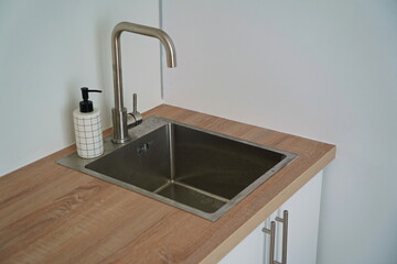 Kitchen sink and hanging cabinets for plates and utensils.
