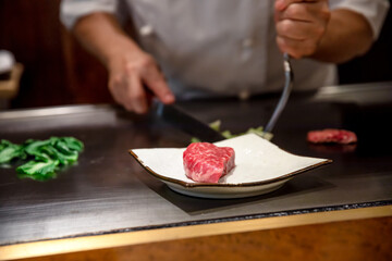 鉄板焼きステーキを料理人が調理している