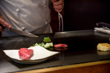鉄板焼きステーキを料理人が調理している