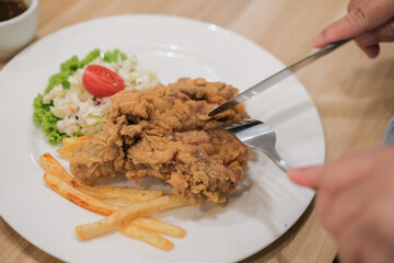 A plate of chicken chop set come with french fries ,  coleslaw and carrot milk ice