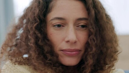 Sick woman with covid, cold or flu while sitting on the couch at home. Worried female suffering with anxiety about corona symptoms covering herself with a blanket, anxious, fraid and shivering