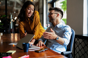 Colleagues in office. Businesswoman and businessman discussing work in office.