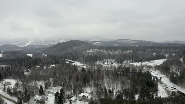 Beautiful winter landscape. Mountains and ski resort in the background. Cinematic 4k drone footage. Professional pilot. Flying pan left. Foggy, overcast