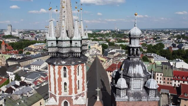Steeple and clock tower at St. Mary's Basilica - City Centre flyover of Krakow, Poland, a Polish cultural capital, with medieval and renaissance architecture - 4K 30FPS Tracking Forward Close Up