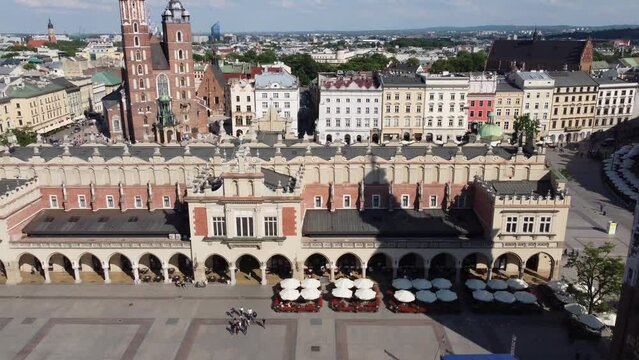The Cloth Hall (Sukiennice) Market and St. Mary's Basilica (Bazylika Mariacka) in the City Centre of Krakow, Poland, a Polish cultural capital with renaissance architecture - 4K 30FPS Tracking Left