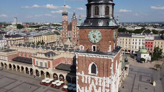 Steeple and clock tower at St. Mary's Basilica - City Centre flyover of Krakow, Poland, a Polish cultural capital, with medieval and renaissance architecture - 4K 30FPS Smooth Tracking Left