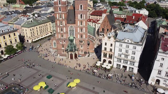 Race near St. Mary's Basilica (Bazylika Mariacka), Clock Tower at the Main Square in Krakow, Poland, a Polish cultural capital, with medieval and renaissance architecture - 4K 30FPS Smooth Tracking Up