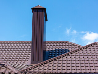 Brown metal pipe on the roof of the house