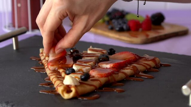 Tasting trying fruit crepe strawberry banana blueberry nutella candy dessert slow motion