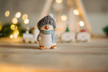 Close up of pinguin toy decoration with with Christmas tree garland lights flickering in...