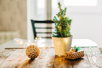Close up of present box decoration with with Christmas tree garland lights flickering in background. shallow depth of field. xmas gift card concept.