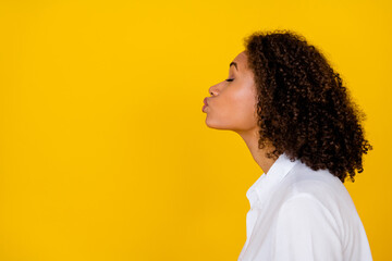 Profile photo of young gorgeous adorable girl wear white blouse send kiss empty space eyes closed isolated on yellow color background