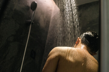asian young man is taking shower in the bathroom - Powered by Adobe