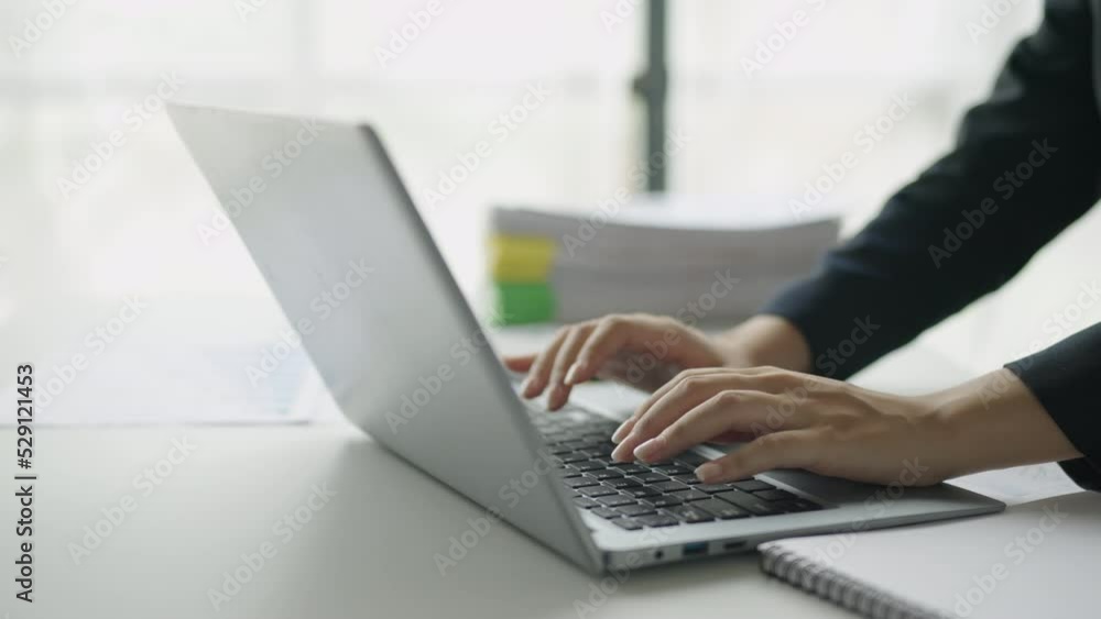 Poster close-up of a woman's hand intently typing using laptop computer at the office fluently and several 