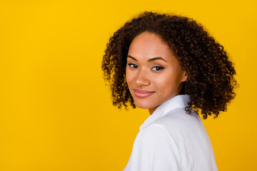 Photo of lovely gorgeous positive girl with curly hair wear white blouse smiling looking at camera isolated on yellow color background