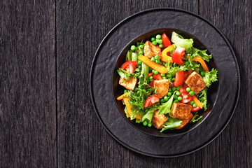 tofu salad with greens and vegetables in bowl