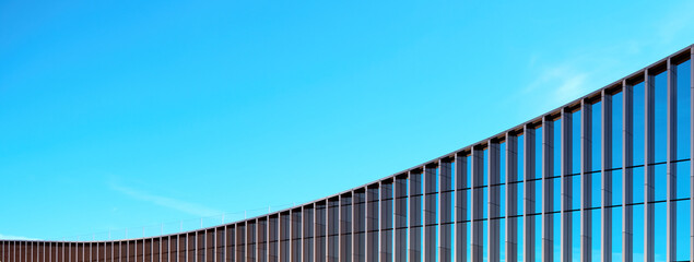 Fragment of the mirror wall of the building against the blue sky...office building covered with glass. Place for an inscription, advertising. Panorama.