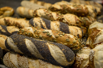many different pretzel rolls with grains and seeds